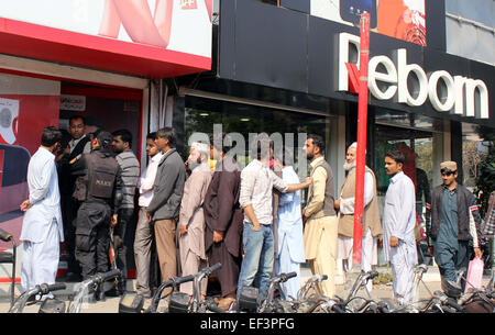 Menschen sind in Warteschlange für Drehung um ihre telefonische Sim Karte Inhaber-Daten, außerhalb eines Customer Care Centers befindet sich in der Nähe von Zainab Markt in Karachi auf Montag, 26. Januar 2015 zu überprüfen. Stockfoto