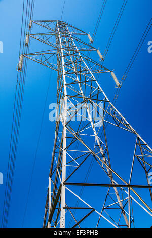 Ein Strommast vor einem wolkenlosen blauen Himmel. Stockfoto