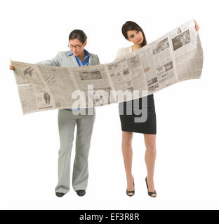 Zwei Frauen, die eine sehr große Zeitung lesen Stockfoto