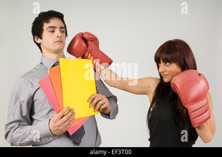 Frau trägt Boxhandschuhe, Geschäftsmann zu schlagen droht Stockfoto