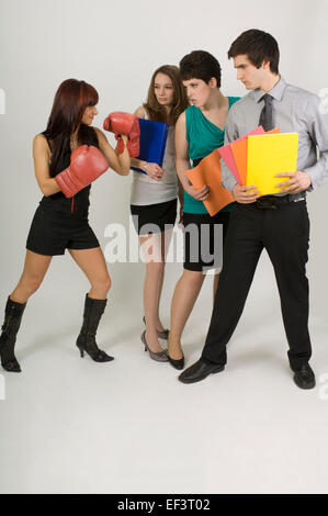 Drei Personen an Frau tragen Boxhandschuhe Stockfoto