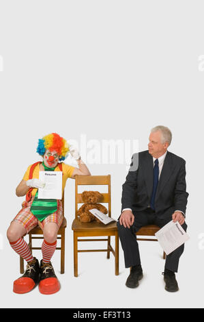 Geschäftsmann und Clown wartet ein interview Stockfoto