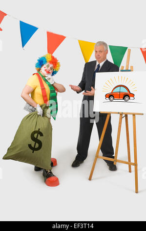 Clown hält einen Beutel mit Geld neben ein Autoverkäufer Stockfoto