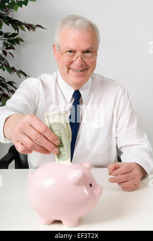 Geschäftsmann, Geld im Sparschwein Stockfoto