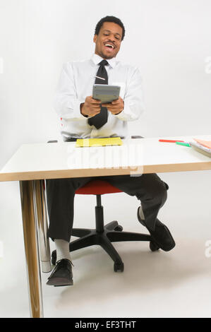 Mann lachen beim Verwenden des Rechners Stockfoto