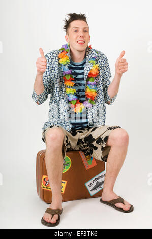 Mann sitzt auf Koffer Stockfoto