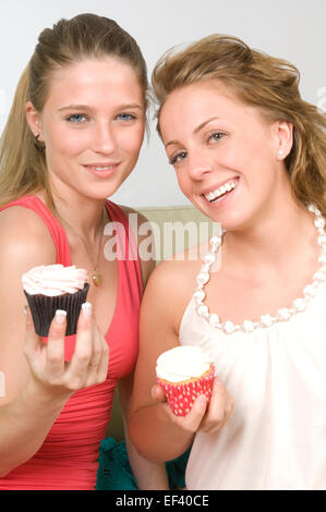 Zwei Frauen halten Muffins Stockfoto