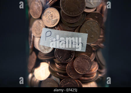 Ein Glas mit 1- und 2-Cent-Münzen mit einem Etikett "Pension". Stockfoto