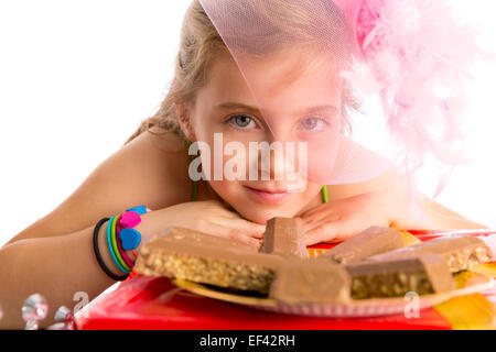 Hungrige Geste blondes Kind Mädchen in Partei mit Schokolade am Geburtstag Stockfoto