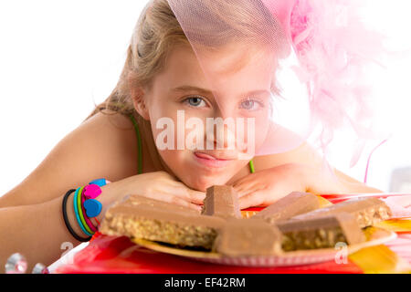 Hungrige Geste blondes Kind Mädchen in Partei mit Schokolade am Geburtstag Stockfoto