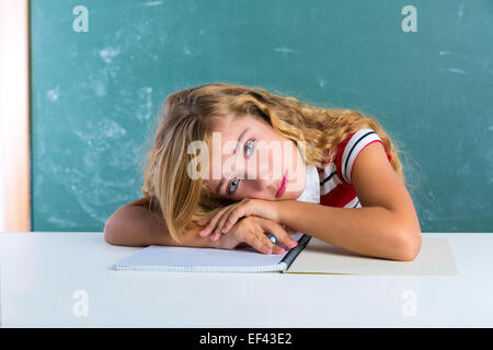 Langweilige traurigen Ausdruck Schüler Schülerin auf Klassenzimmer Schreibtisch bei der Schulbehörde grüne Kreide Stockfoto