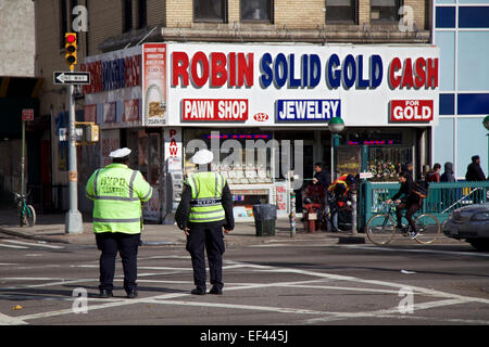 Zwei NYPD Offiziere stehen auf einer Straße in New York, New York und schauen in einem Pfandhaus. Stockfoto