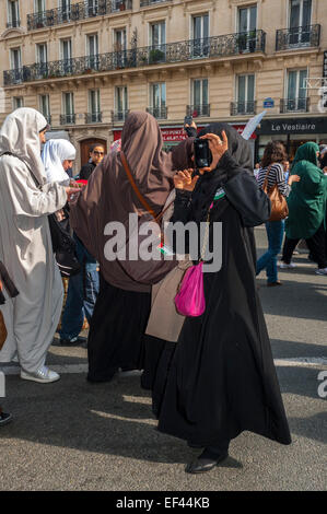 Paris, Frankreich, französische arabische Muslime, die gegen Diskriminierung demonstrierten Islamophobie, Rassismus, versteckten arabische Frauen im Hijab mit iPhone, die Fotos machten, Smartphones, öffentliche Leute, französische Mobiltelefone Stockfoto