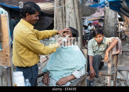 Agra, Indien, Südasien. Am Straßenrand Barbier auf Kinari Basar, im Herzen der Altstadt Stockfoto