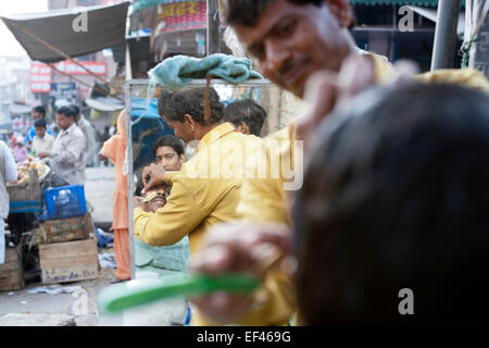 Agra, Indien, Südasien. Am Straßenrand Barbier auf Kinari Basar, im Herzen der Altstadt Stockfoto