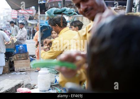 Agra, Indien, Südasien. Am Straßenrand Barbier auf Kinari Basar, im Herzen der Altstadt Stockfoto