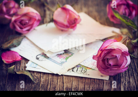 Trocken Sie rosa Rosen und alten Brief auf hölzernen Hintergrund Stockfoto