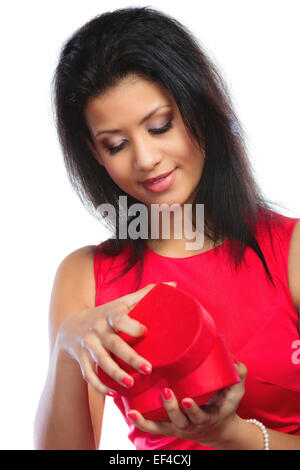 Glück, Valentinstag und Liebe Konzept. Attraktive, elegante Frau im roten Kleid, Mädchen gemischt Rennen Eröffnung rotes Herz Form Geschenk Stockfoto