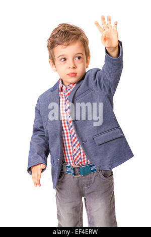 Kleiner Junge mit Jacke und seine Hand hob auf weißem Hintergrund Stockfoto