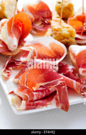 Nahaufnahme einer Platte mit typisch spanischen Pincho de Tortilla und Pincho de Jamon, spanische Omelette und Serrano-Schinken, serviert auf b Stockfoto