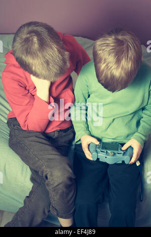 Zwei jungen im Schlafzimmer ein Videospiel spielen. Stockfoto