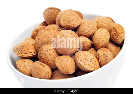 Nahaufnahme einer Schüssel mit Mandeln in der Schale auf einem weißen Hintergrund Stockfoto