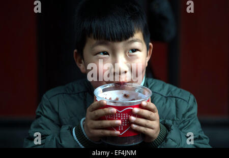 (150127) - CHENGDU, 27. Januar 2015 (Xinhua) ein Junge isst Laba Congee in einem buddhistischen Tempel in Chengdu, Hauptstadt der südwestlichen chinesischen Provinz Sichuan, 27. Januar 2015. Laba, ein traditionelles chinesisches fest gefeiert am 8. Tag des 12. Mondmonats, fiel am 27. Januar in diesem Jahr. Es ist eine Tradtion Laba Congee anlässlich des Festivals zu essen, und es ist auch eine Tradition von einigen Tempeln und Non-Profit-Organisationen zu die Congee an diesem Tag kostenlos zu verteilen. (Xinhua/Jiang Hongjing) (Hcx) Stockfoto