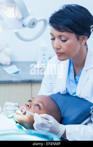 Zahnärztin, die jungen Zähne untersuchen Stockfoto