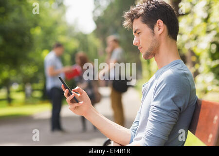 Hübsche Studentin SMS außerhalb Stockfoto