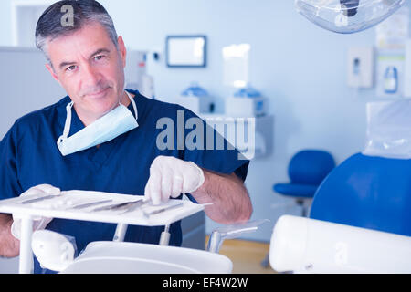 Zahnarzt Werkzeug aufnehmen und in die Kamera Lächeln Stockfoto