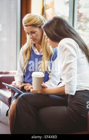 Fokussierte Geschäftskollegen holding Kaffeetasse und tablet Stockfoto
