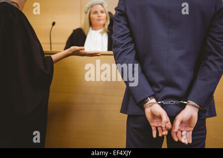 Richter im Gespräch mit der Verbrecher in Handschellen Stockfoto