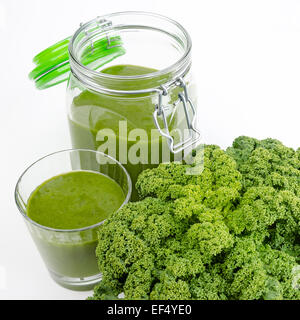 Grüner Smoothie im Glas und in einem offenen Glas mit frischen Grünkohl. Ein rohes, gesunde vegane Getränk der grünen Blätter und Früchte. Stockfoto