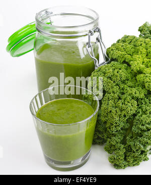 Grüner Smoothie im Glas und in einem offenen Glas mit frischen Grünkohl. Ein rohes, gesunde vegane Getränk der grünen Blätter und Früchte. Stockfoto