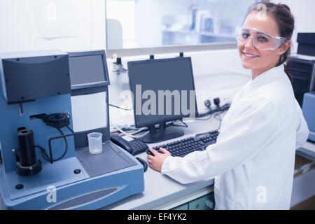 Porträt eines lächelnden jungen Wissenschaftlers mit Schutzbrille Stockfoto