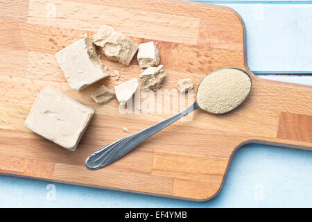 Frische und getrocknete Hefe auf Schneidebrett Stockfoto