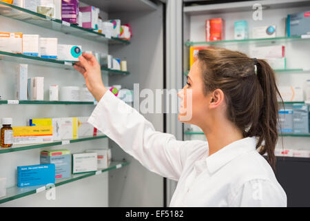 Junior Apotheker Einnahme von Regal Stockfoto