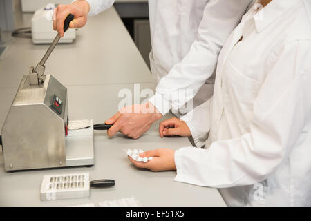 Team von Apothekern mit Presse Pillen machen Stockfoto