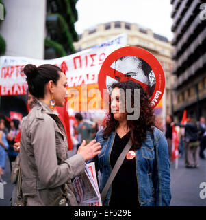 Zwei junge Frauen sprechen in der Straße mit Banner am Tag der Demonstration in Athen, Griechenland Europa EU-KATHY DEWITT Stockfoto