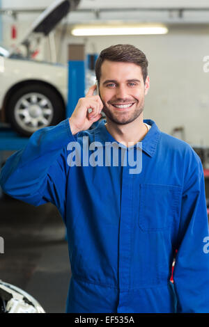 Lächelnde Mechaniker auf dem Handy Stockfoto