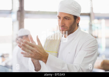 Baker, klatschte Mehl aus seinen Händen Stockfoto
