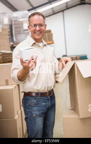 Lächelnd hält kleine Box Lagerarbeiter Stockfoto