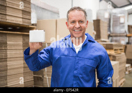 Lächelnd hält kleine Box Lagerarbeiter Stockfoto