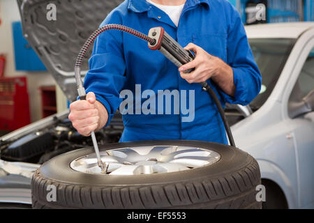 Nahaufnahme des Mechanikers Aufpumpen des Reifens Stockfoto