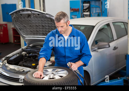 Fokussierte Mechaniker Aufpumpen des Reifens Stockfoto