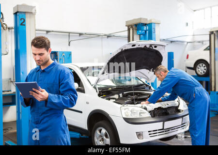 Konzentrierte Mechaniker in Zwischenablage schreiben Stockfoto