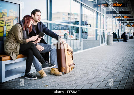 Junges Paar warten vor dem Flughafengebäude Stockfoto