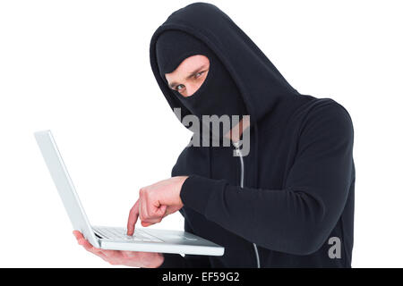 Hacker in Balaclava Tippen auf laptop Stockfoto