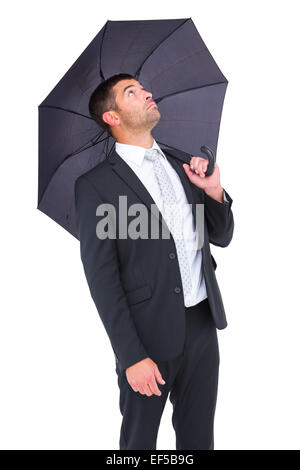 Geschäftsmann bergende unter schwarzen Regenschirm Stockfoto