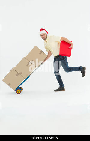 Lieferung Mann schob Trolley-Boxen in der Weihnachtszeit Stockfoto